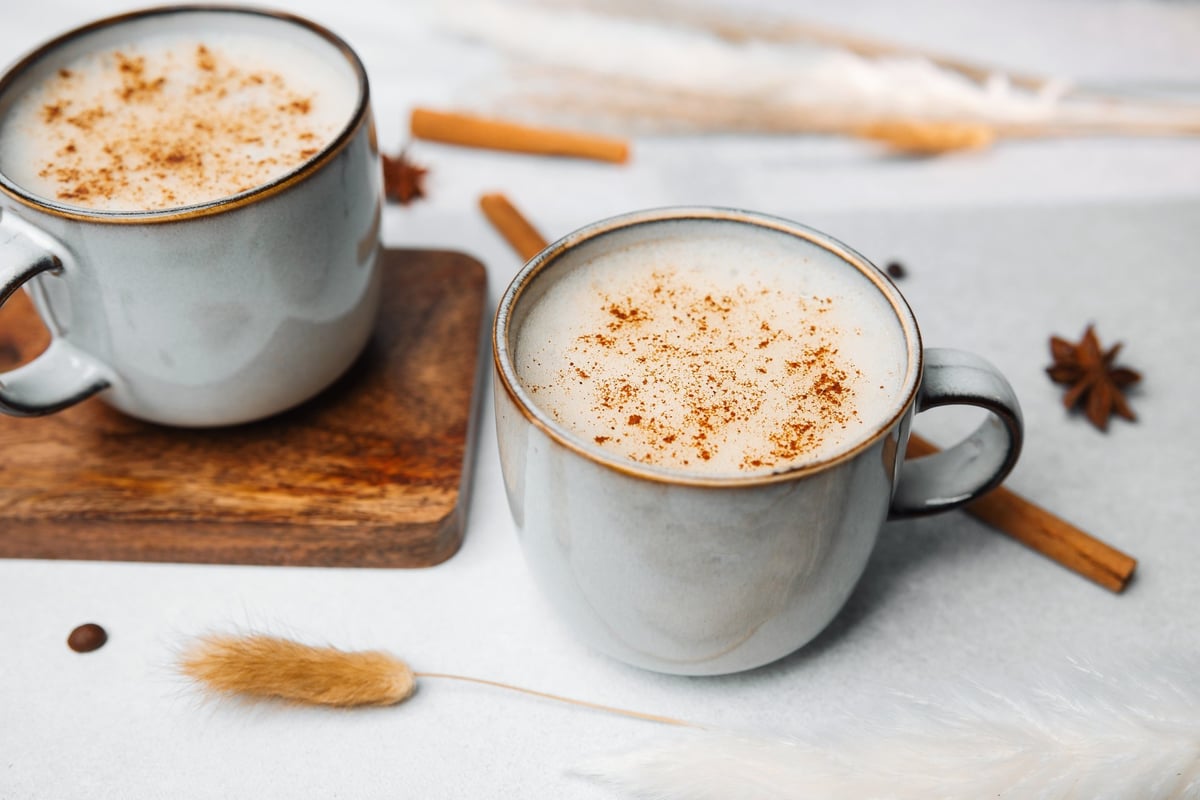 Milky spiced tea in ceramic mugs with whole spices, the style of Somali Shaah